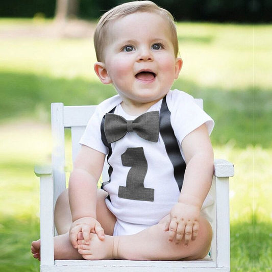 Baby boy's 1st birthday bow tie romper with suspenders, perfect for a smash cake photoshoot.
