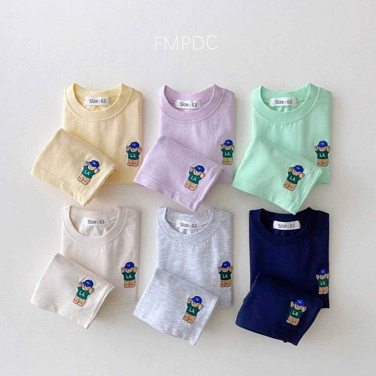 Detail of the comfortable elastic waistband on the baby boy's white shorts, part of a summer set