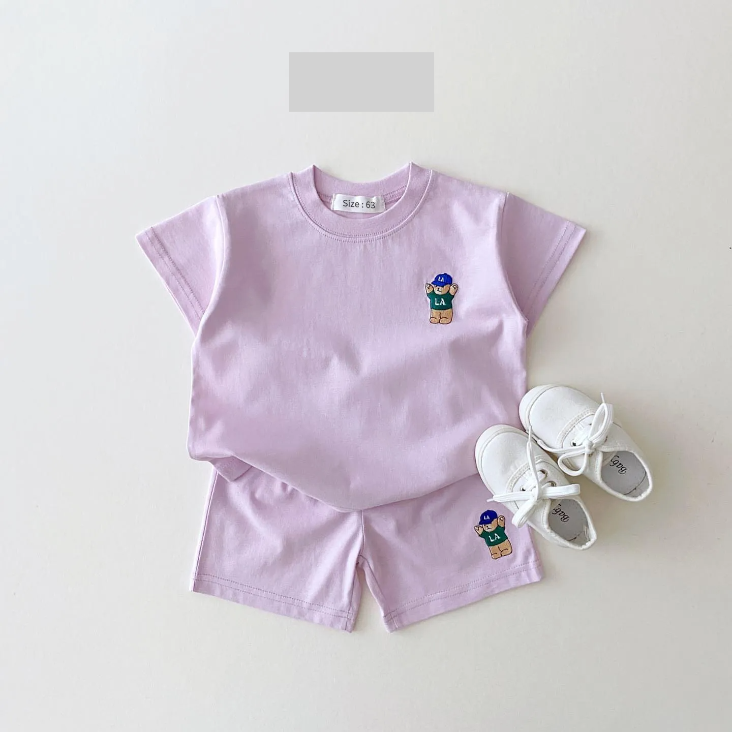 Close-up of bear embroidery on a baby boy's blue cotton blend t-shirt, cute infant apparel detail