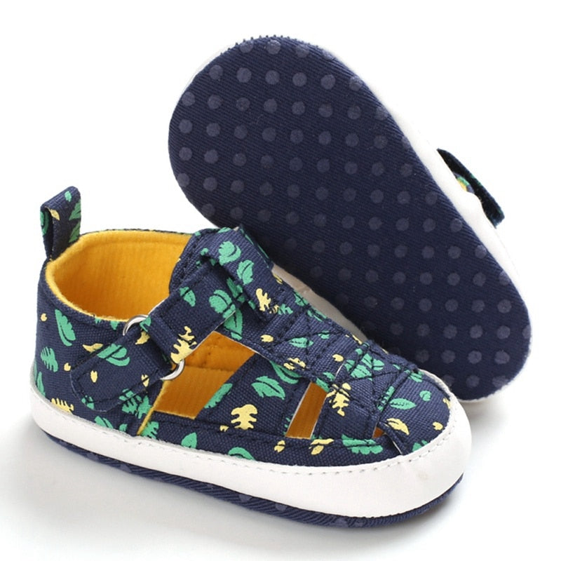 Close up of baby boy printed soft sole sandal, showing anti-slip bottom and secure snap