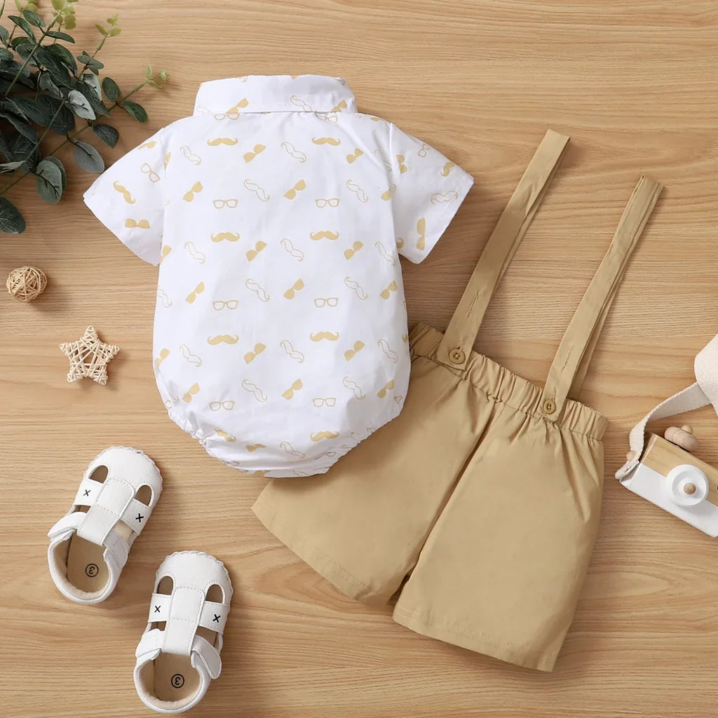 White bow tie bodysuit for baby boy paired with navy blue suspender pants, ideal baby formalwear
