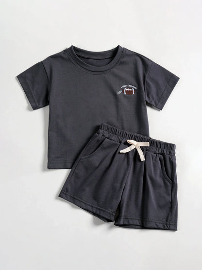Toddler boy's summer outfit: white short-sleeve tee with daisy motif, matching blue shorts