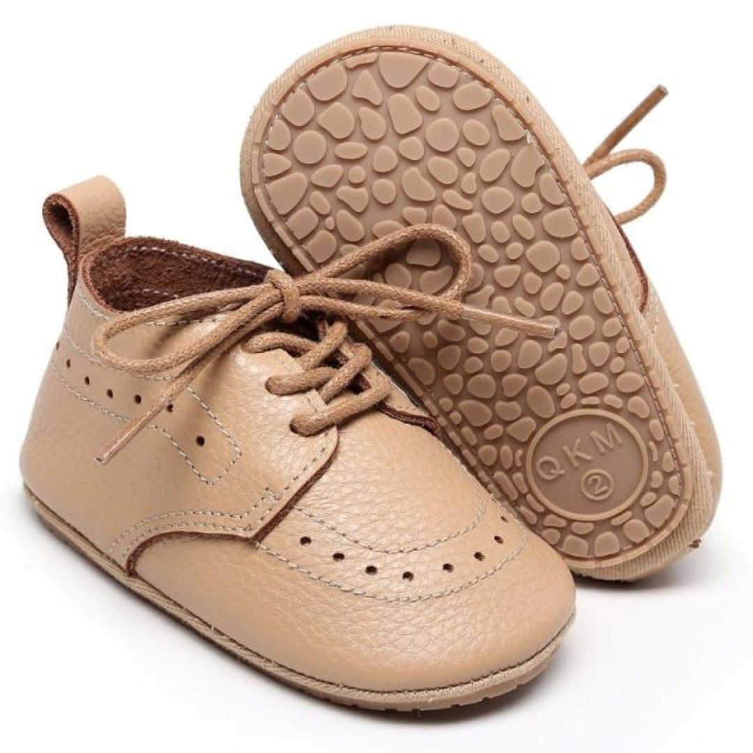 Top-down view of infant boy soft sole shoes, durable leather and secure lace-up closure