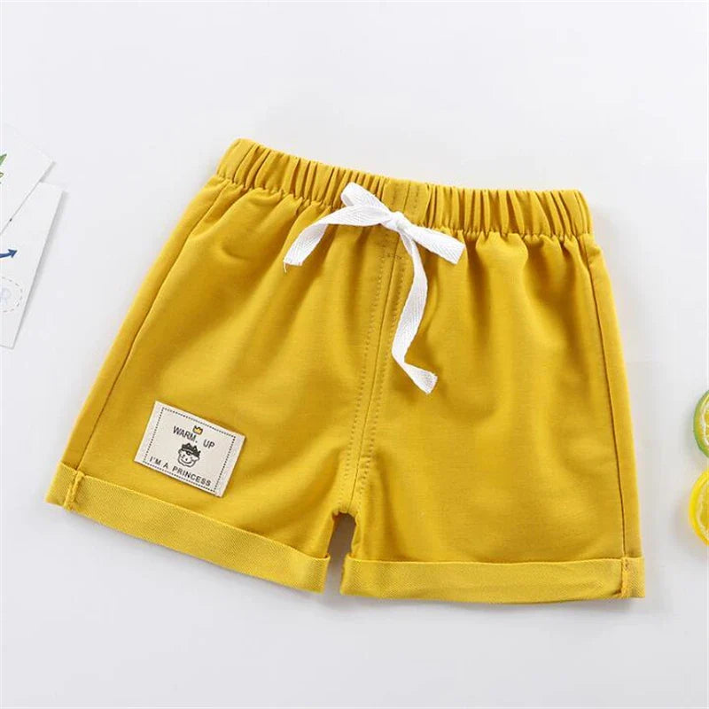 Toddler boy in blue loose fit summer shorts, ideal casual baby clothing for warm weather.