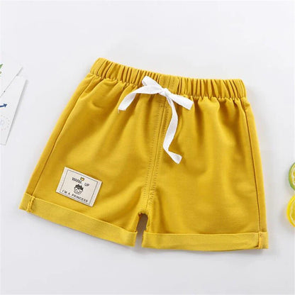 Toddler boy in blue loose fit summer shorts, ideal casual baby clothing for warm weather.