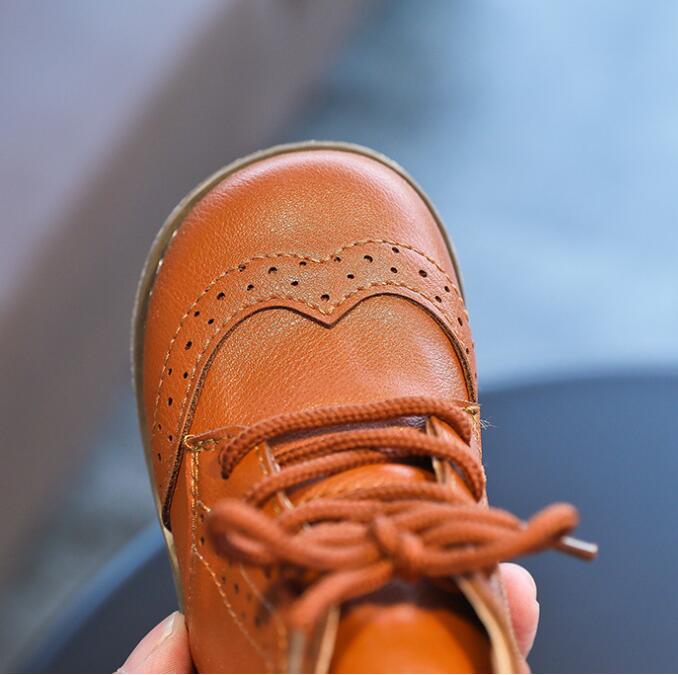 Close-up of a baby boy's tan leather brogue first walker shoe with soft sole, ideal for toddler anti-slip footwear.