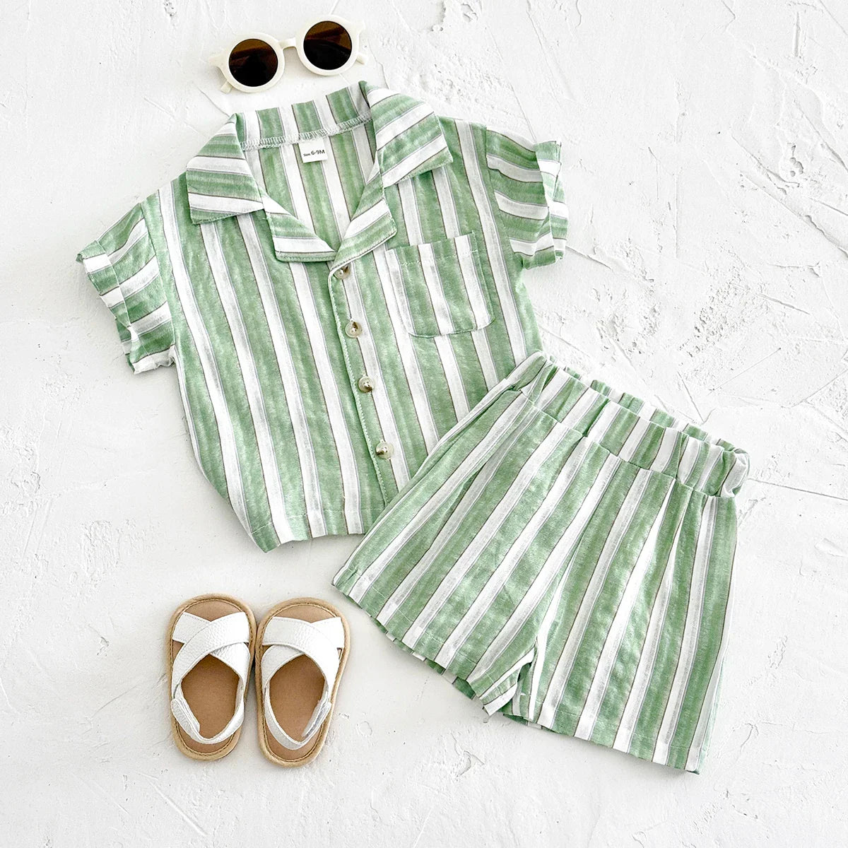 Close-up of green and white striped baby shirt with lapel collar and buttons