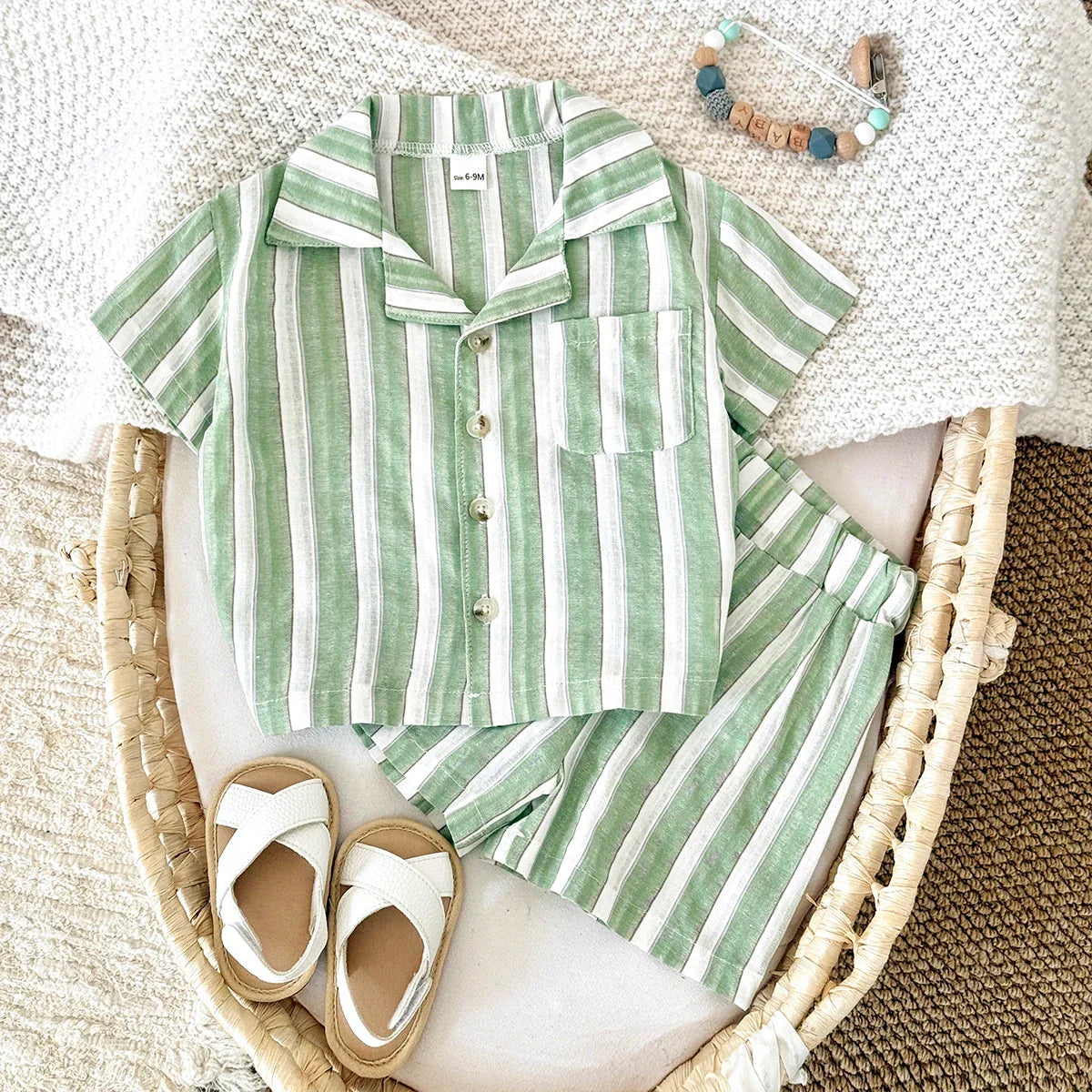 Toddler in a green stripe lapel shirt and matching shorts playing happily outdoors