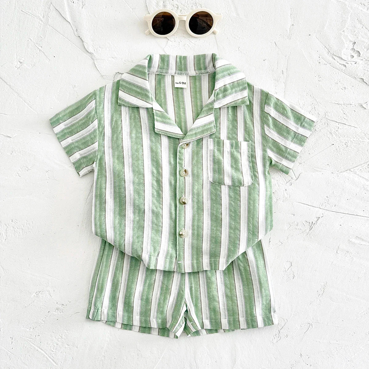 Green stripe baby boys girls summer outfit from a slightly elevated angle