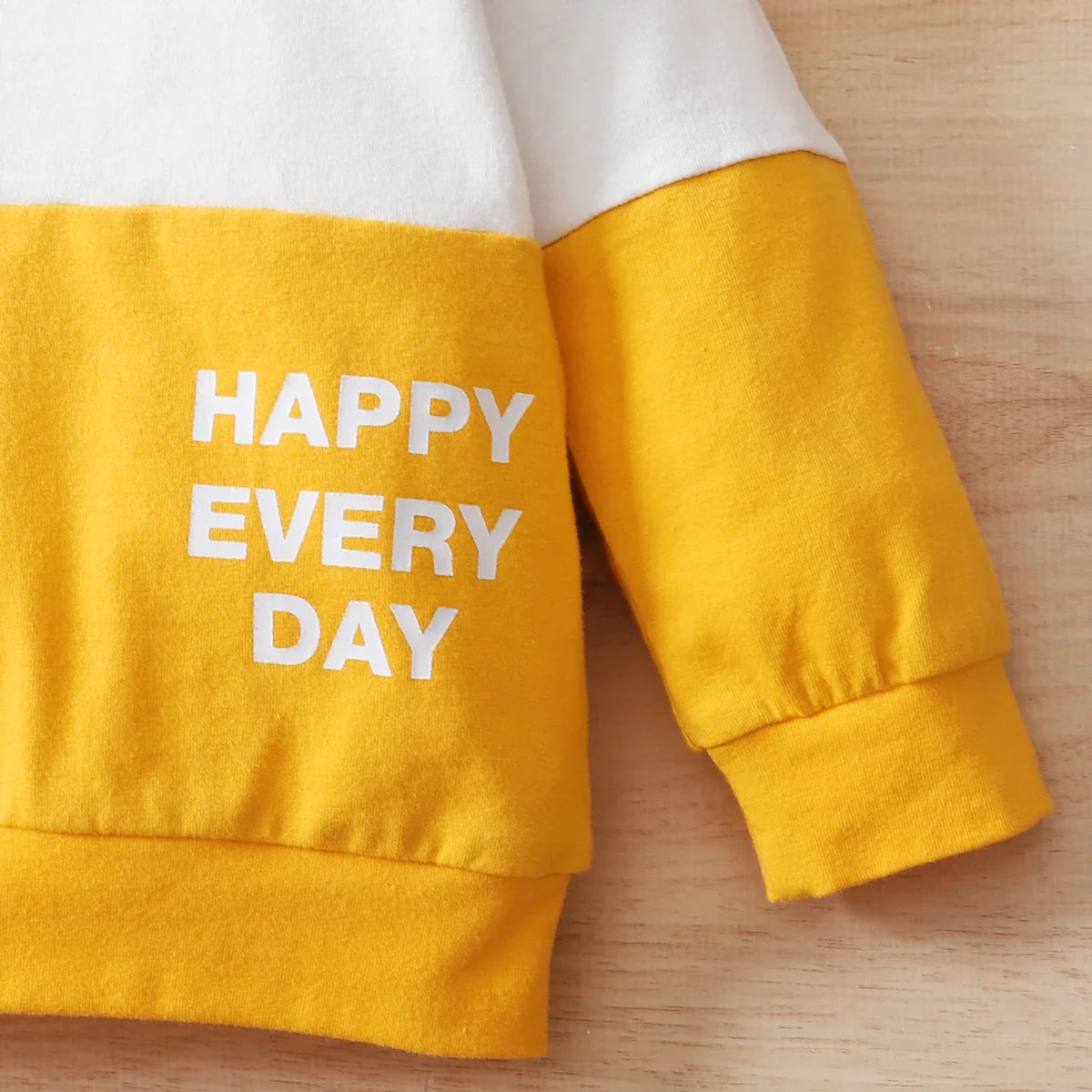 Detail of the patchwork print on the baby boy's sport casual top, high-quality stitching