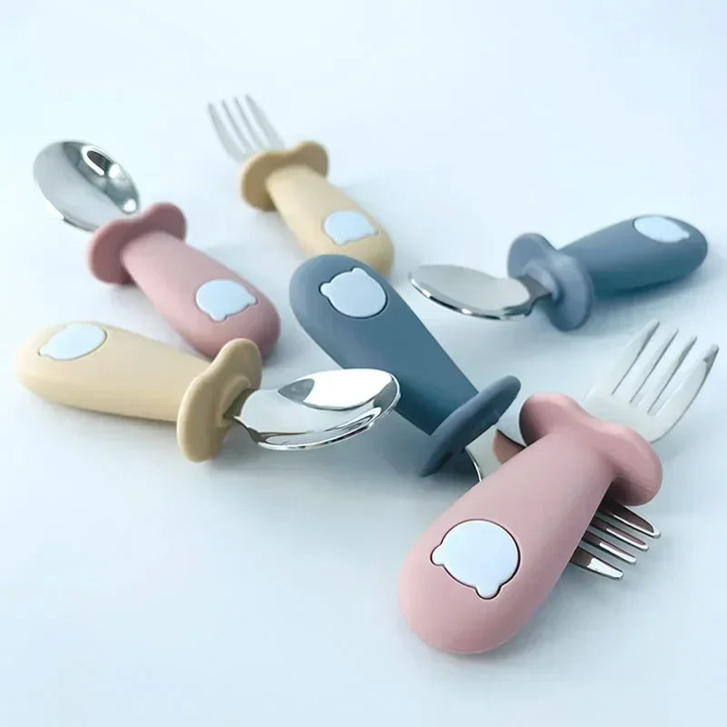 Kids tableware featuring stainless steel spoon with a blue cartoon elephant handle, baby dinnerware
