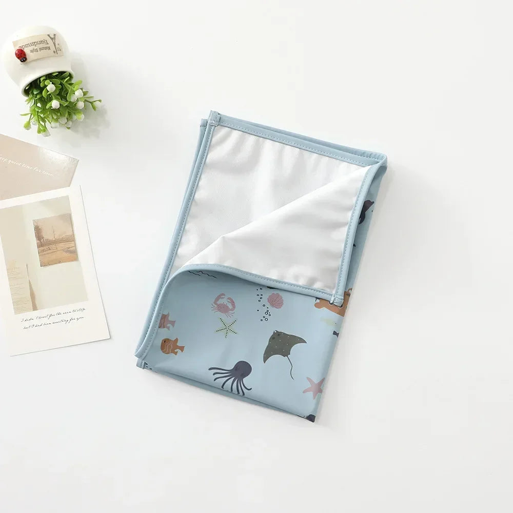 Washable infant changing pad with a cute pattern, perfect for toddler care.
