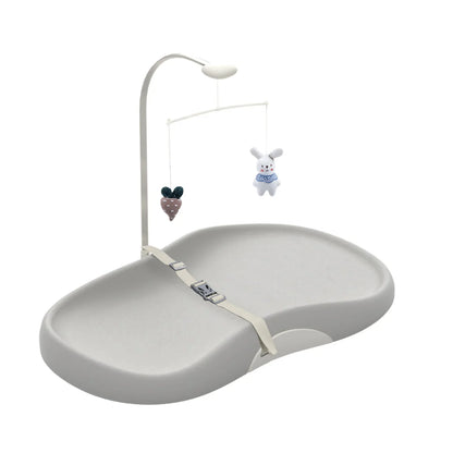 Contoured wipe-clean baby changing pad with safety strap and toy bar for nursery.
