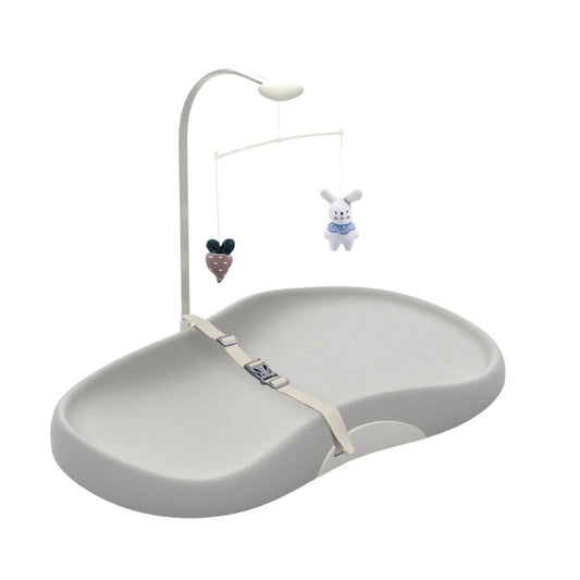 Contoured wipe-clean baby changing pad with safety strap and toy bar for nursery.