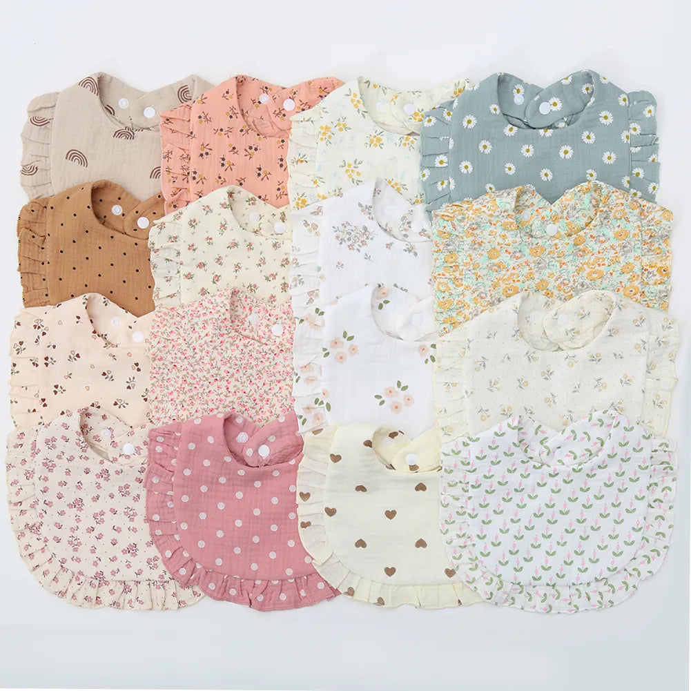 Baby cotton bib with delicate flower print and adjustable snap closure, perfect for newborn feeding.
