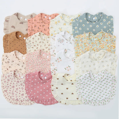 Baby cotton bib with delicate flower print and adjustable snap closure, perfect for newborn feeding.