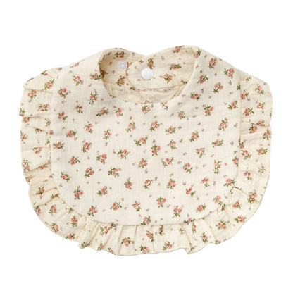 Newborn essential: cotton bib with detailed flower print and adjustable snap, for tidy mealtime.