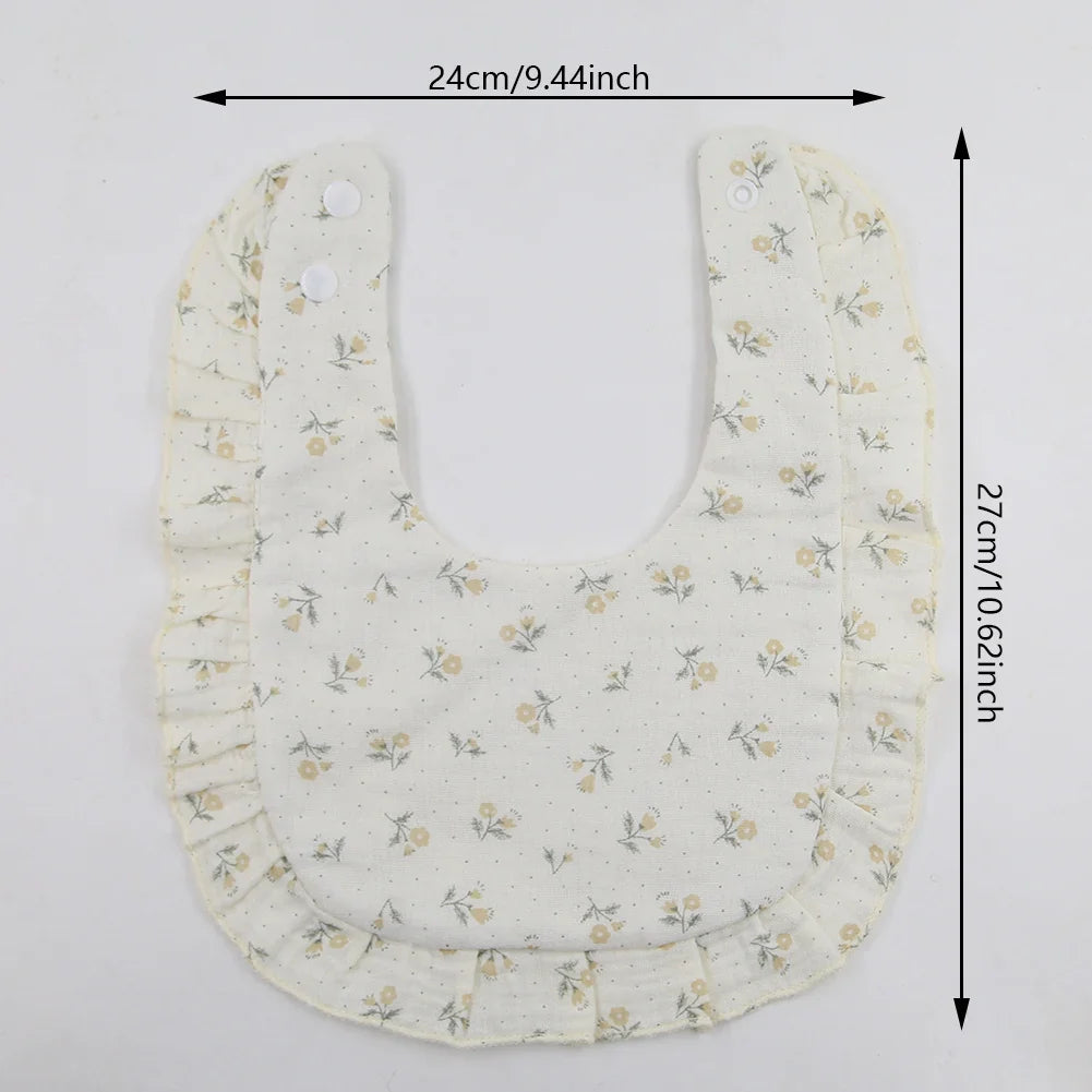 Close-up of a baby cotton bib with a vibrant flower print pattern and secure, adjustable snap.