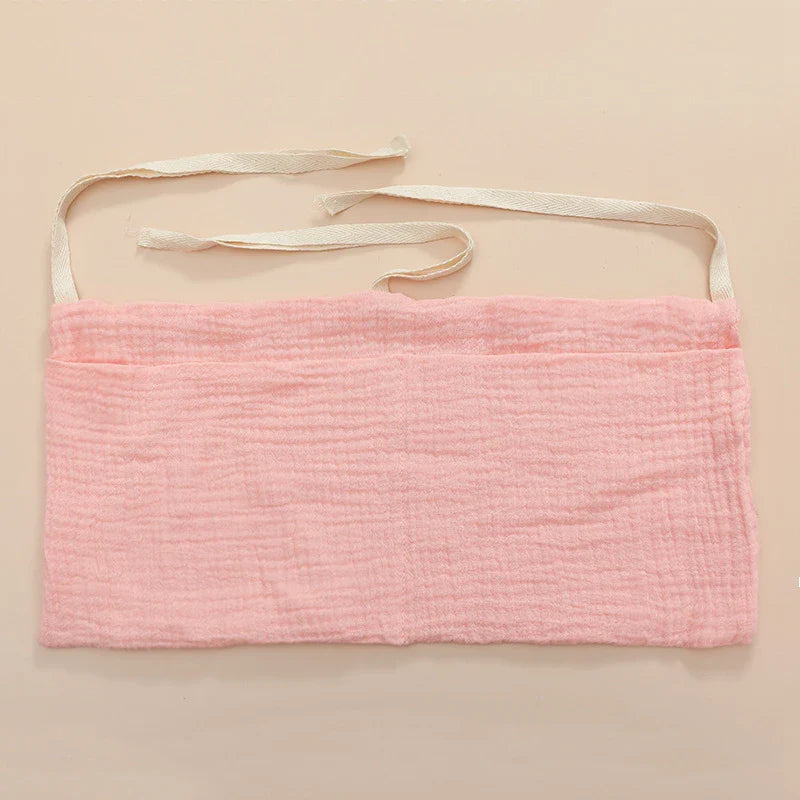 Versatile cotton organizer for nursing accessories, hanging conveniently from a baby crib.