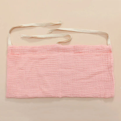 Versatile cotton organizer for nursing accessories, hanging conveniently from a baby crib.