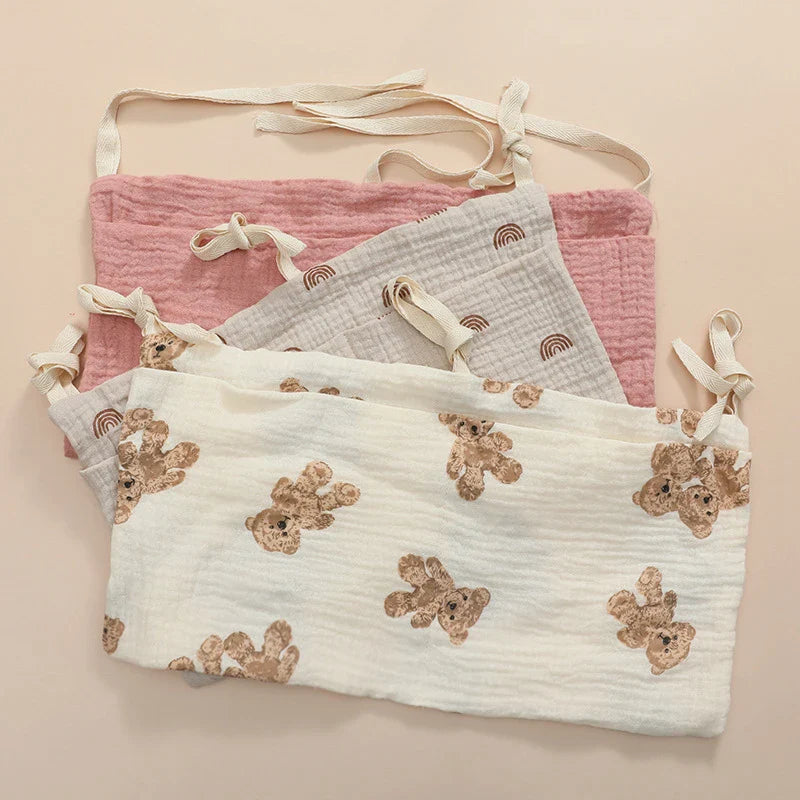 Soft gray cotton crib storage bag with multiple pockets, perfect for baby essentials & diapers.