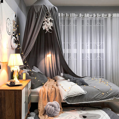 Portable baby dome mosquito net draped over a travel crib, ideal for outdoor baby safety