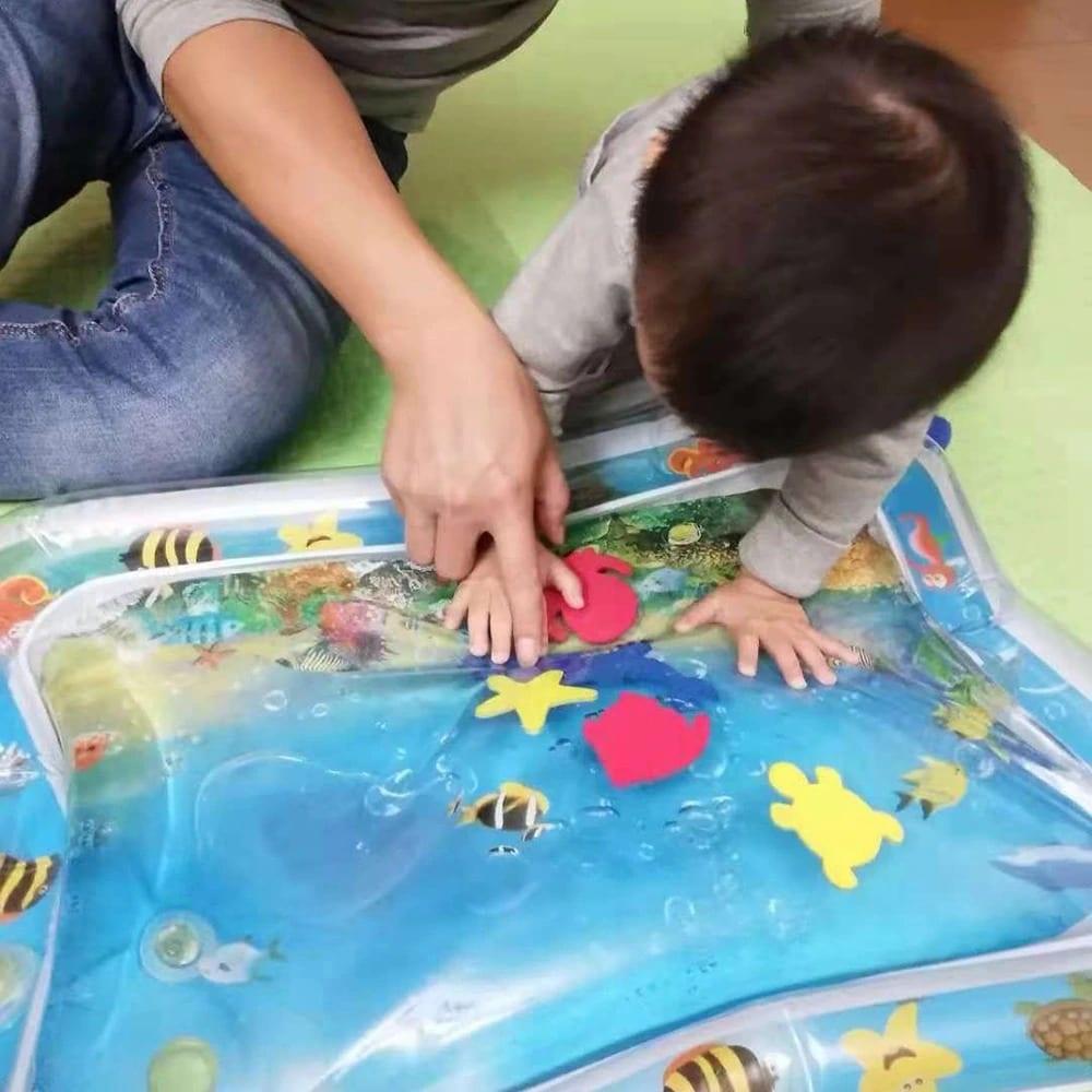 Overhead view of a baby sensory water mat, filled with vibrant marine-themed floating elements.