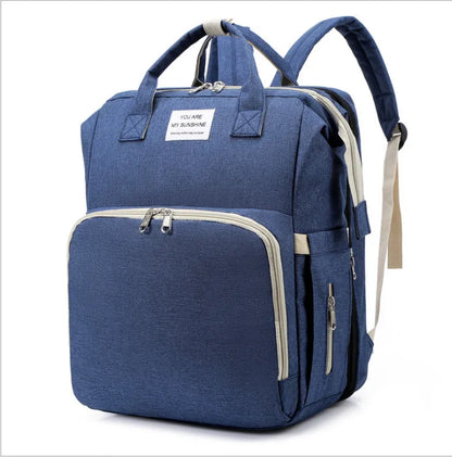 New parent gift: baby backpack with foldable crib, USB charger, and portable changing station.