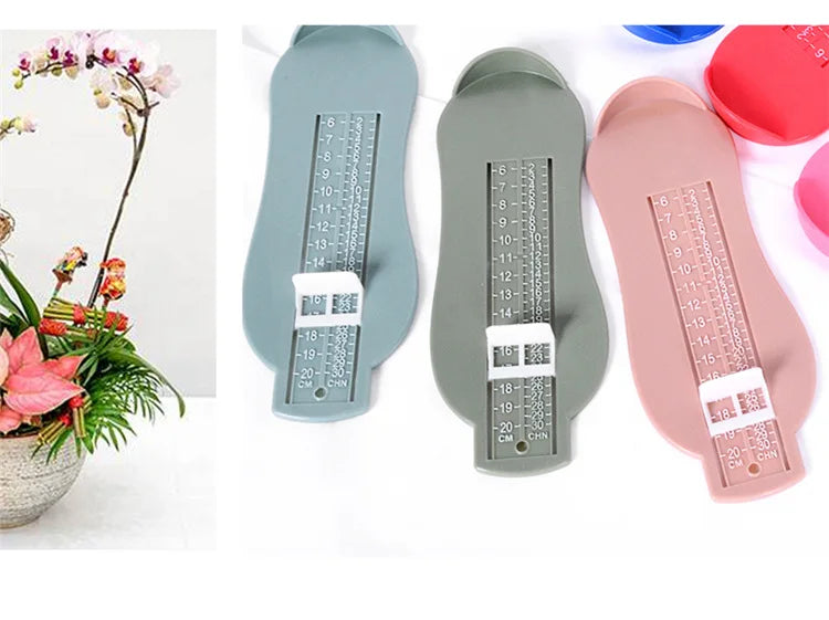 Foot development aid: Baby foot measurement gauge tool next to baby socks