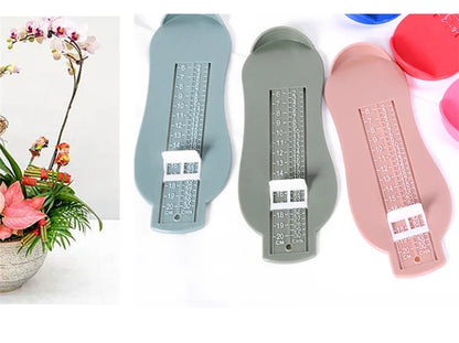 Foot development aid: Baby foot measurement gauge tool next to baby socks