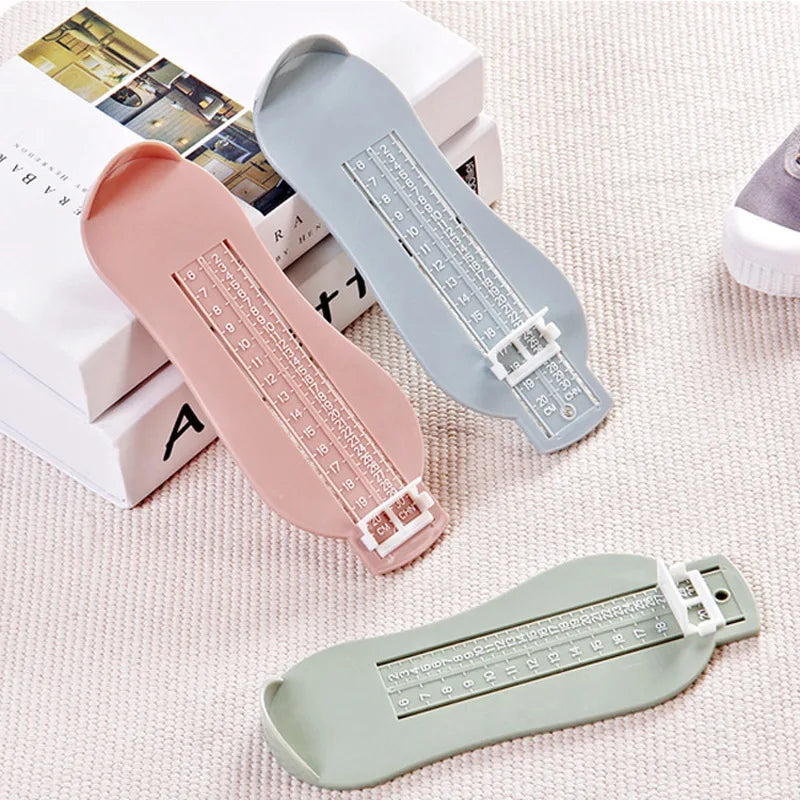 Toddler's foot being measured by a white baby foot measurement gauge tool