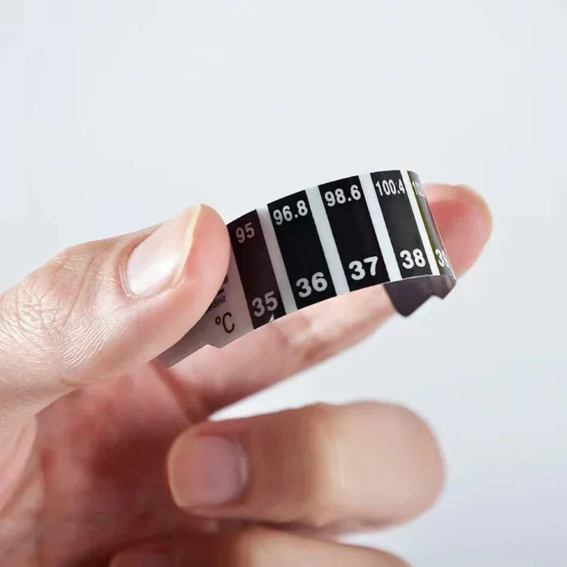 Close-up of baby forehead temperature indicator strip showing blue fever reading