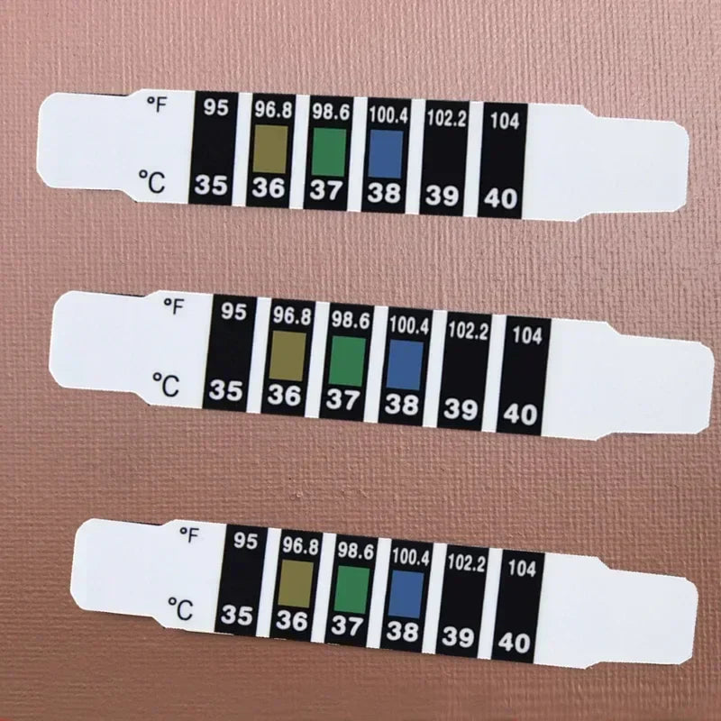 Close-up of baby forehead temperature strip indicating normal body temperature