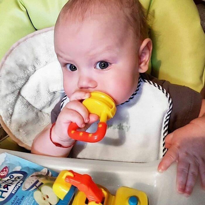 Two brightly colored baby fruit pacifiers and teethers, aiding in safe infant feeding and gum relief.