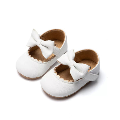 Close-up of the anti-slip soft sole on a pink baby girl first walker bow shoe