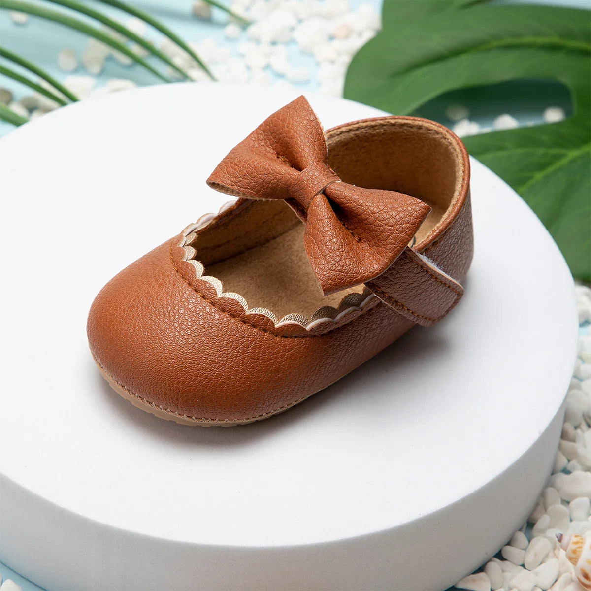 Detail of the soft sole and bow on a pink baby girl anti-slip first walker shoe