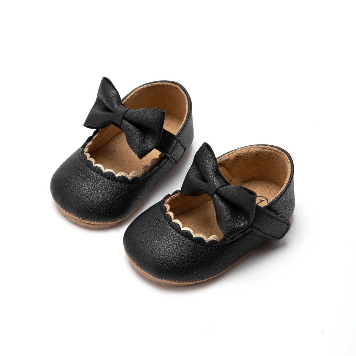 Side view of a baby girl's first walker shoe, anti-slip soft sole and decorative bow