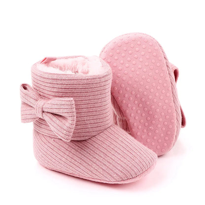 Close up photo of the soft knitted texture of baby girl's bowknot winter boots