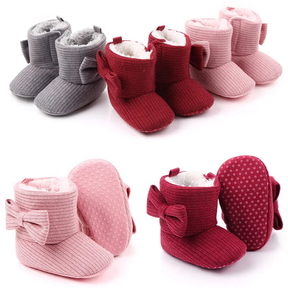 Close up of baby girl's cozy knitted bowknot boots, perfect for winter, soft sole