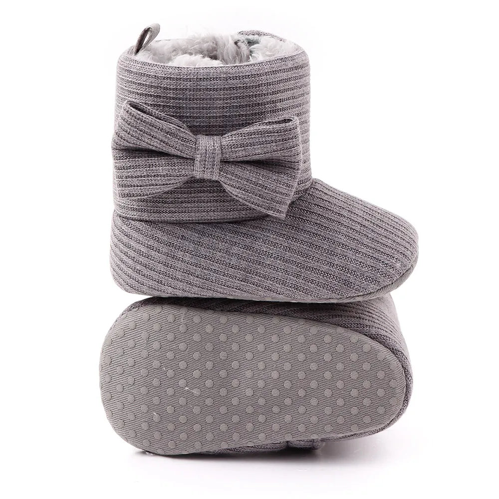 Studio shot of baby girl's cozy bowknot ankle boots, ideal for cold weather