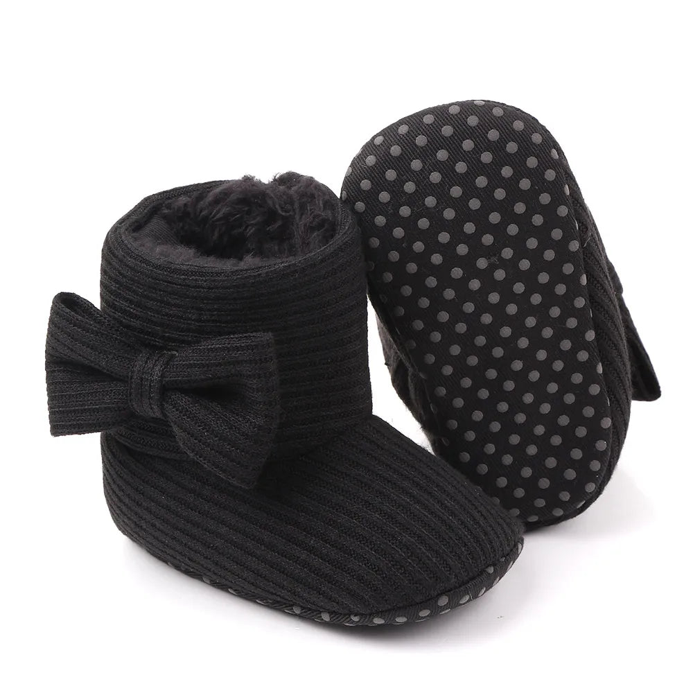 Detail of the soft sole on baby girl's pink bowknot winter walking shoes