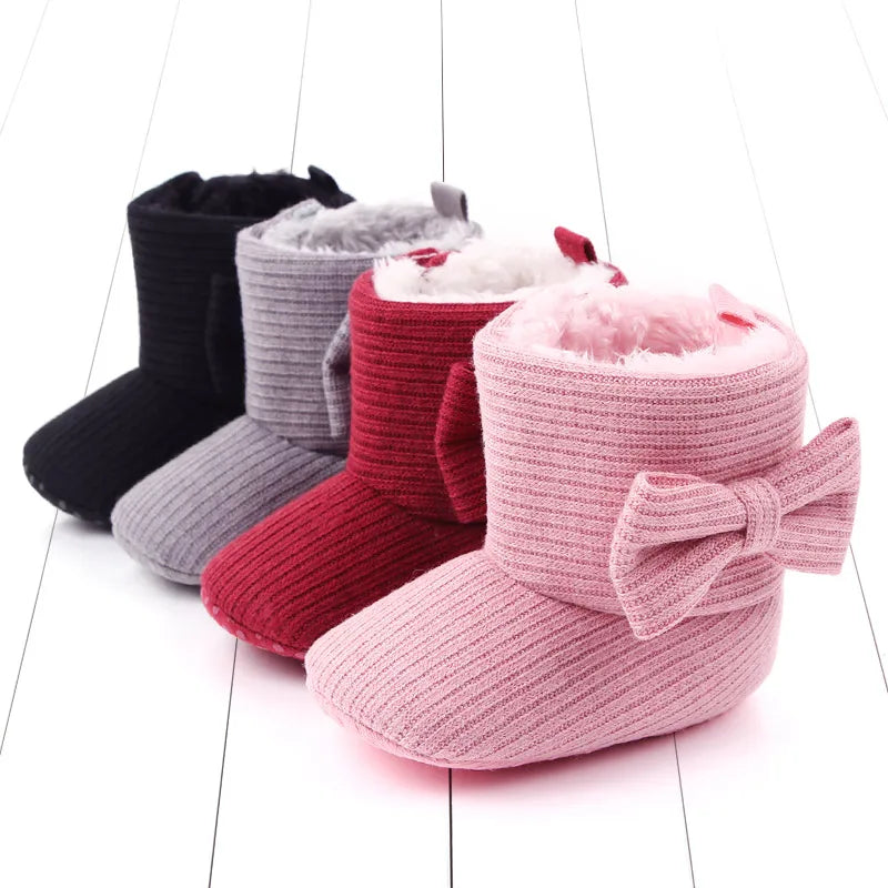 Front view of baby girl pink winter slip-on boots with cute bowknot, first walker shoes