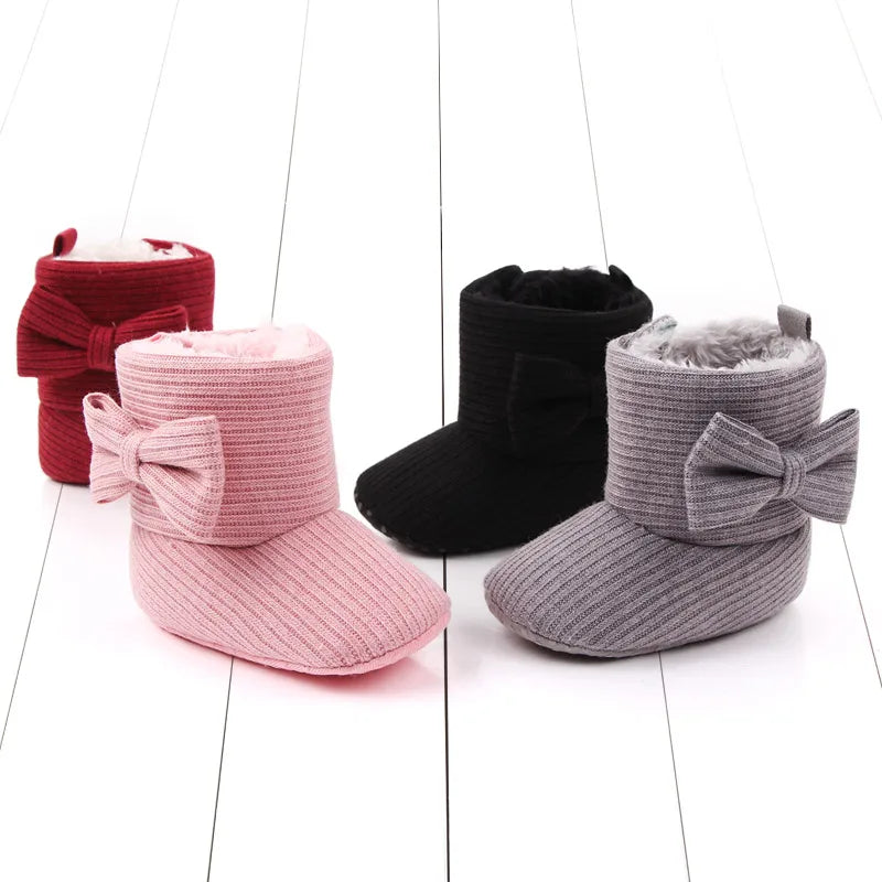Side profile of infant's soft sole bowknot ankle boots for cozy winter walking