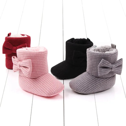 Side profile of infant's soft sole bowknot ankle boots for cozy winter walking