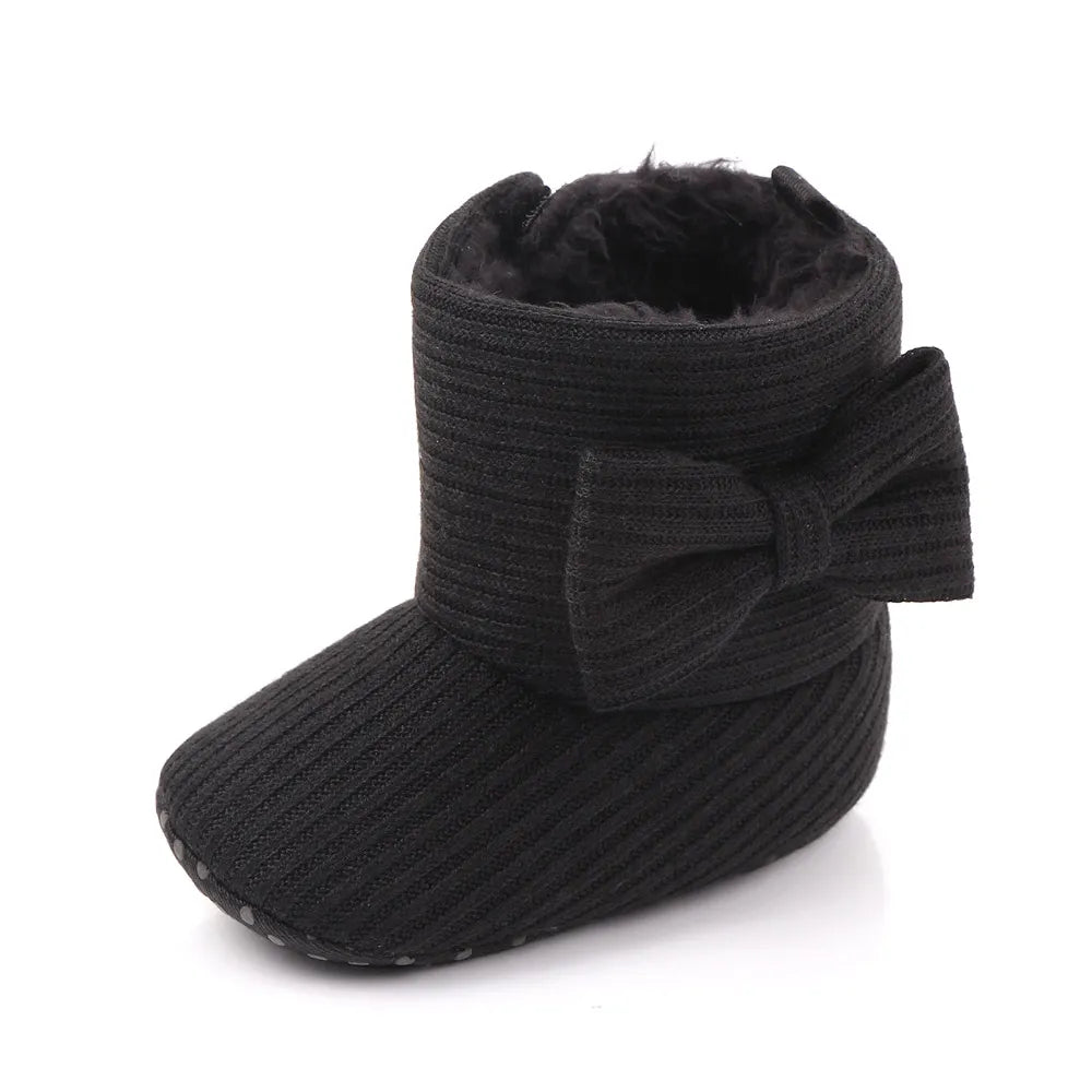 Top down view of baby girl slip-on winter boots with decorative bowknot, infant footwear