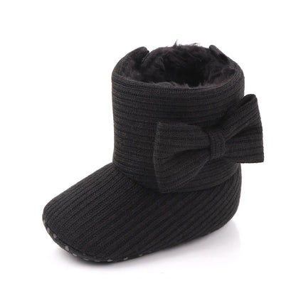 Top down view of baby girl slip-on winter boots with decorative bowknot, infant footwear