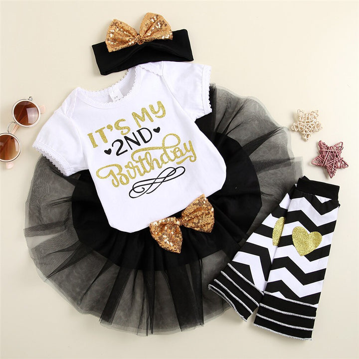 Close-up of a baby girl first birthday romper with 'One' print, tutu detail & leggings fabric