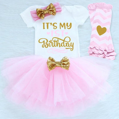 Toddler girl first birthday party outfit featuring a 'One' romper, pink tutu & leggings