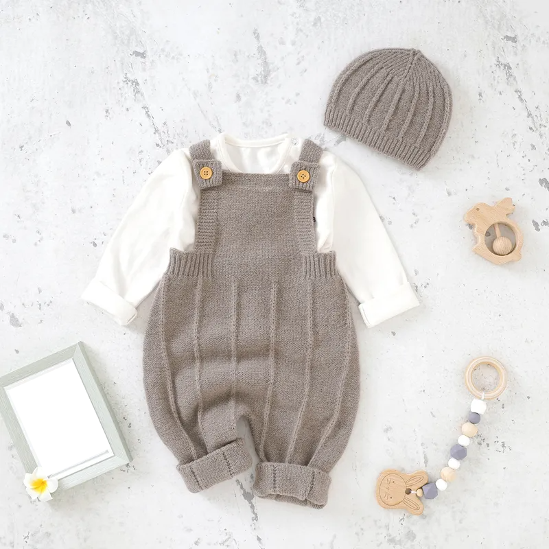 Side view of a baby girl's knitted sleeveless romper and hat set, featuring knit details