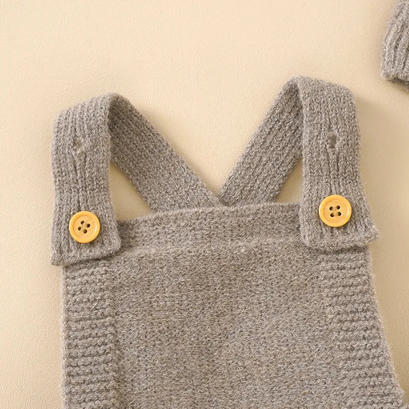 Detailed texture of the acrylic knit on a baby girl's sleeveless romper and hat set